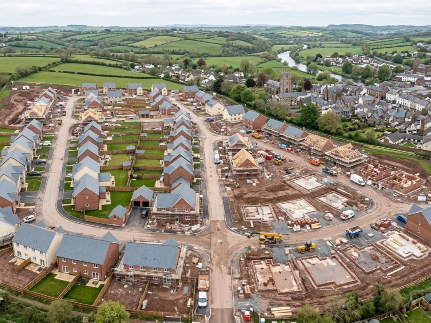 Aerial photograph of a new housing development site mid construction, plots and roads laid out in sequence