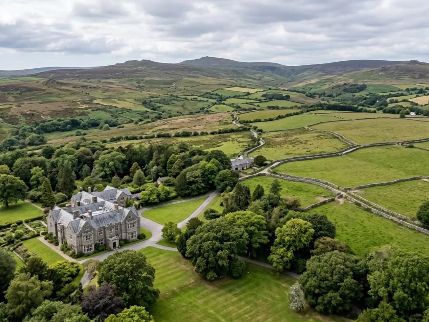 Aerial view of open Dartmoor-edge countryside with a country house and parkland below